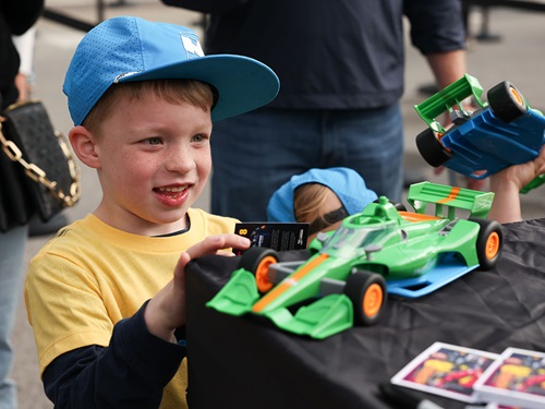 A child looks at a small car