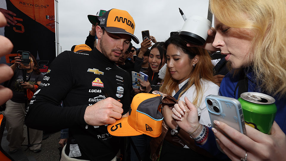 Pato O'Ward signs autographs for fans